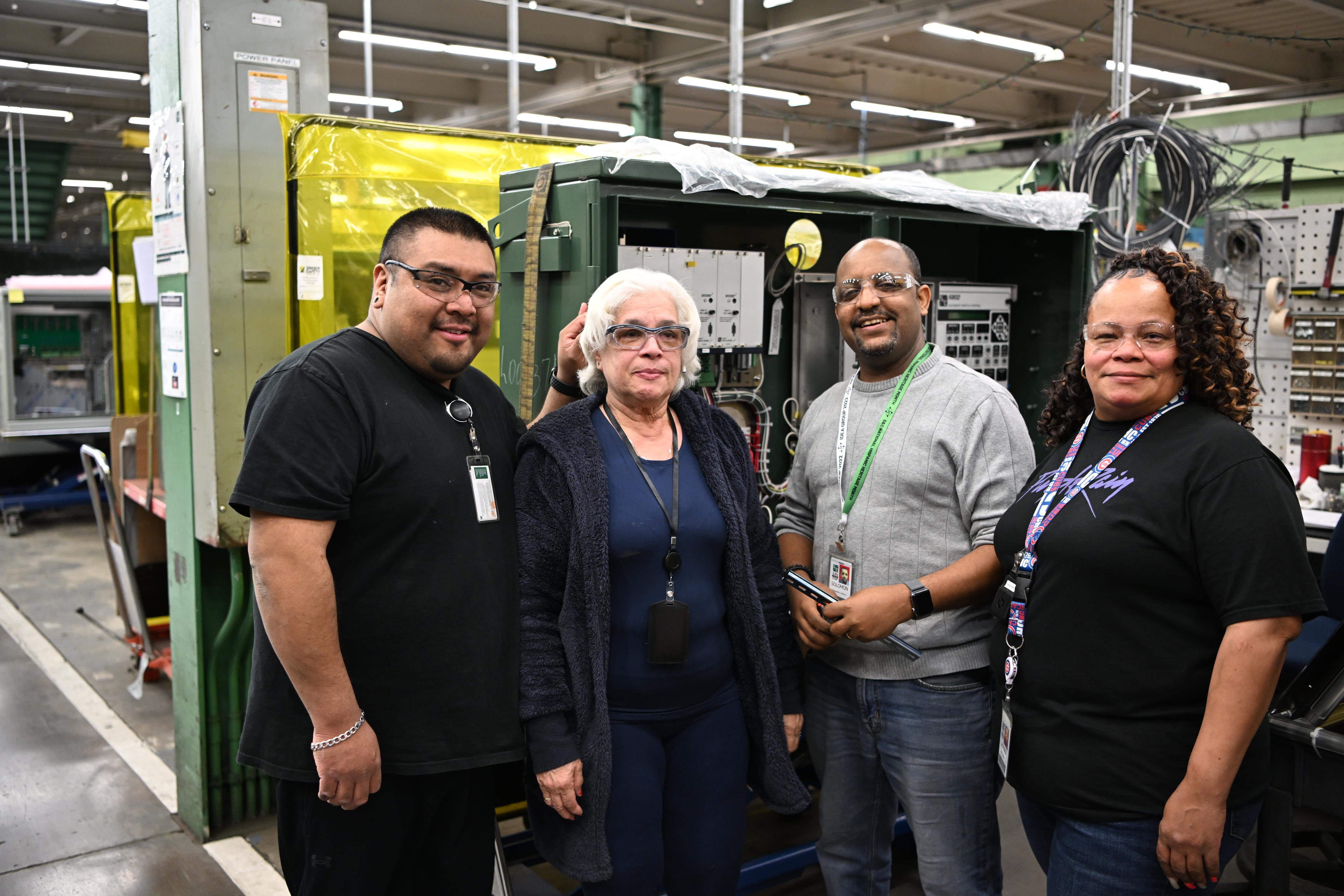 Four team members pose on the manufacturing floor